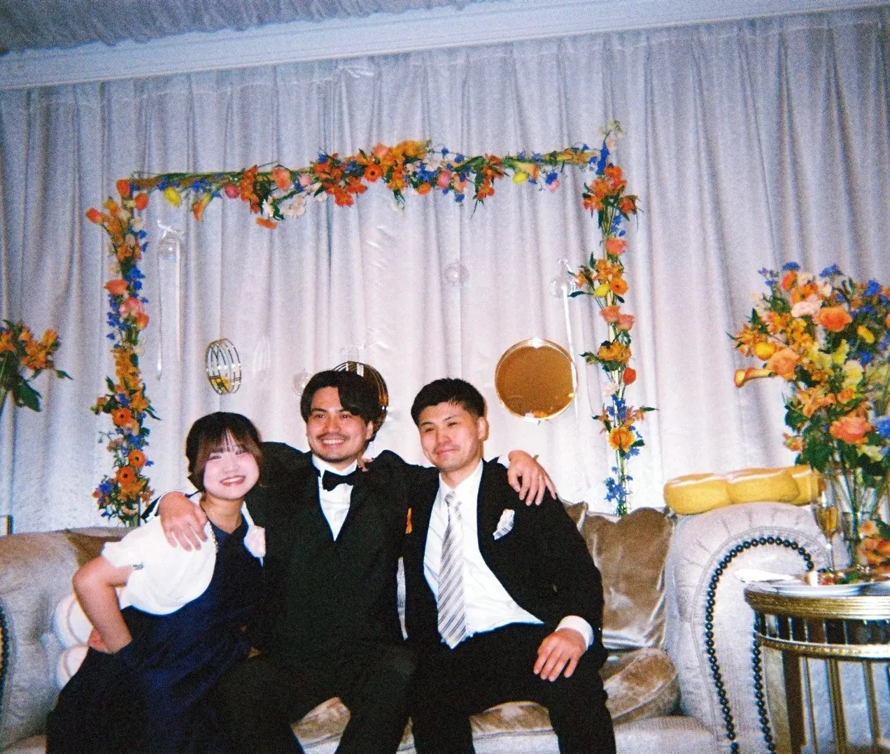 高砂のソファで新郎新婦と写るゲスト