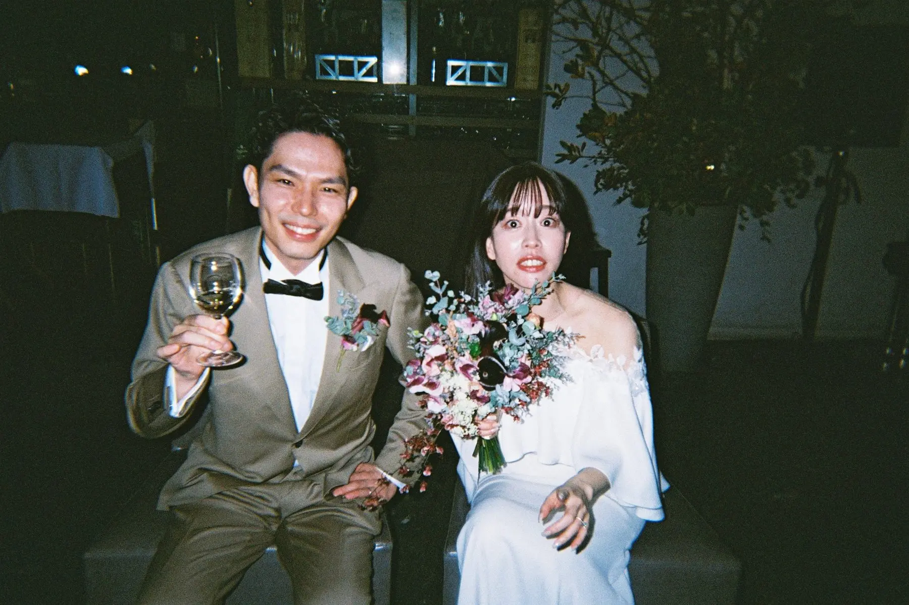 グラスを掲げる新郎と、ブーケを持つ新婦