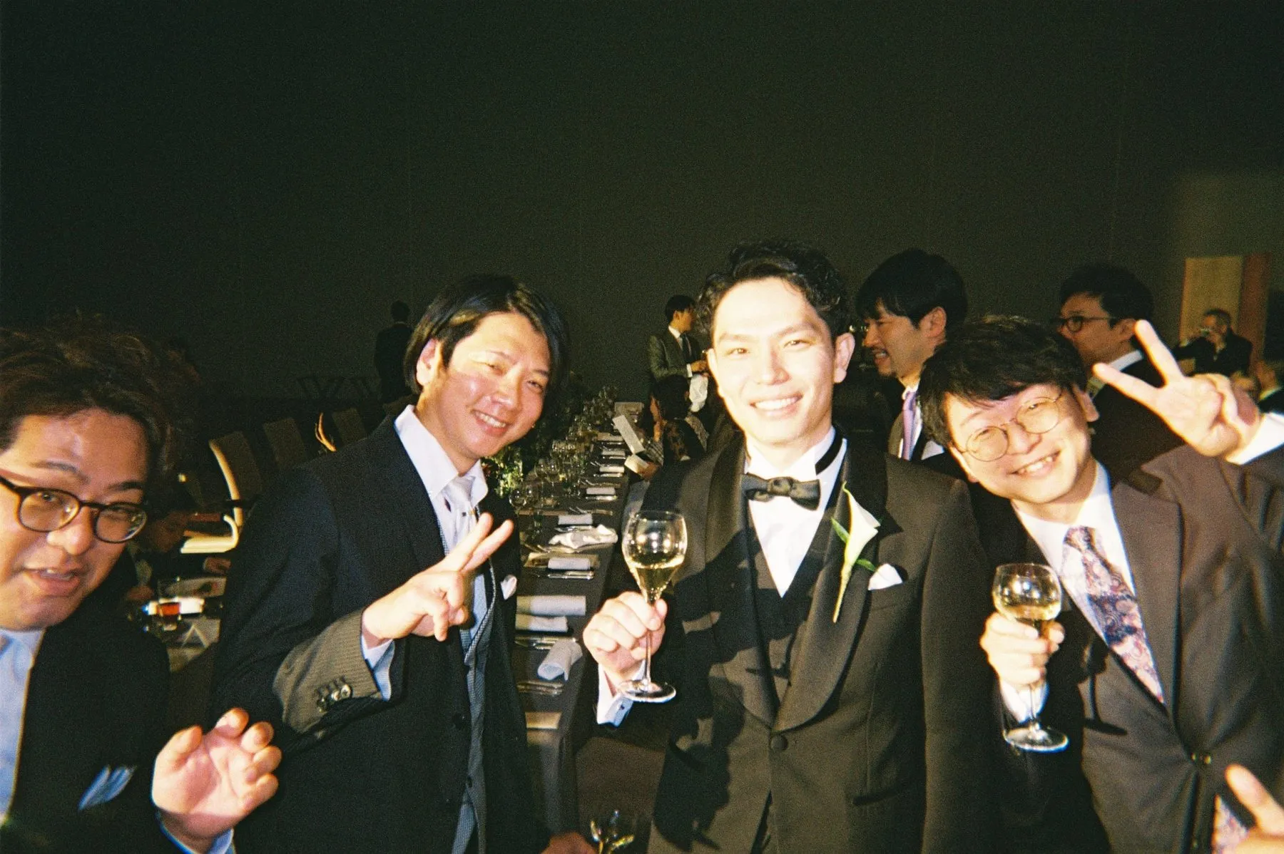 グラスを手に、新郎とピースするゲスト