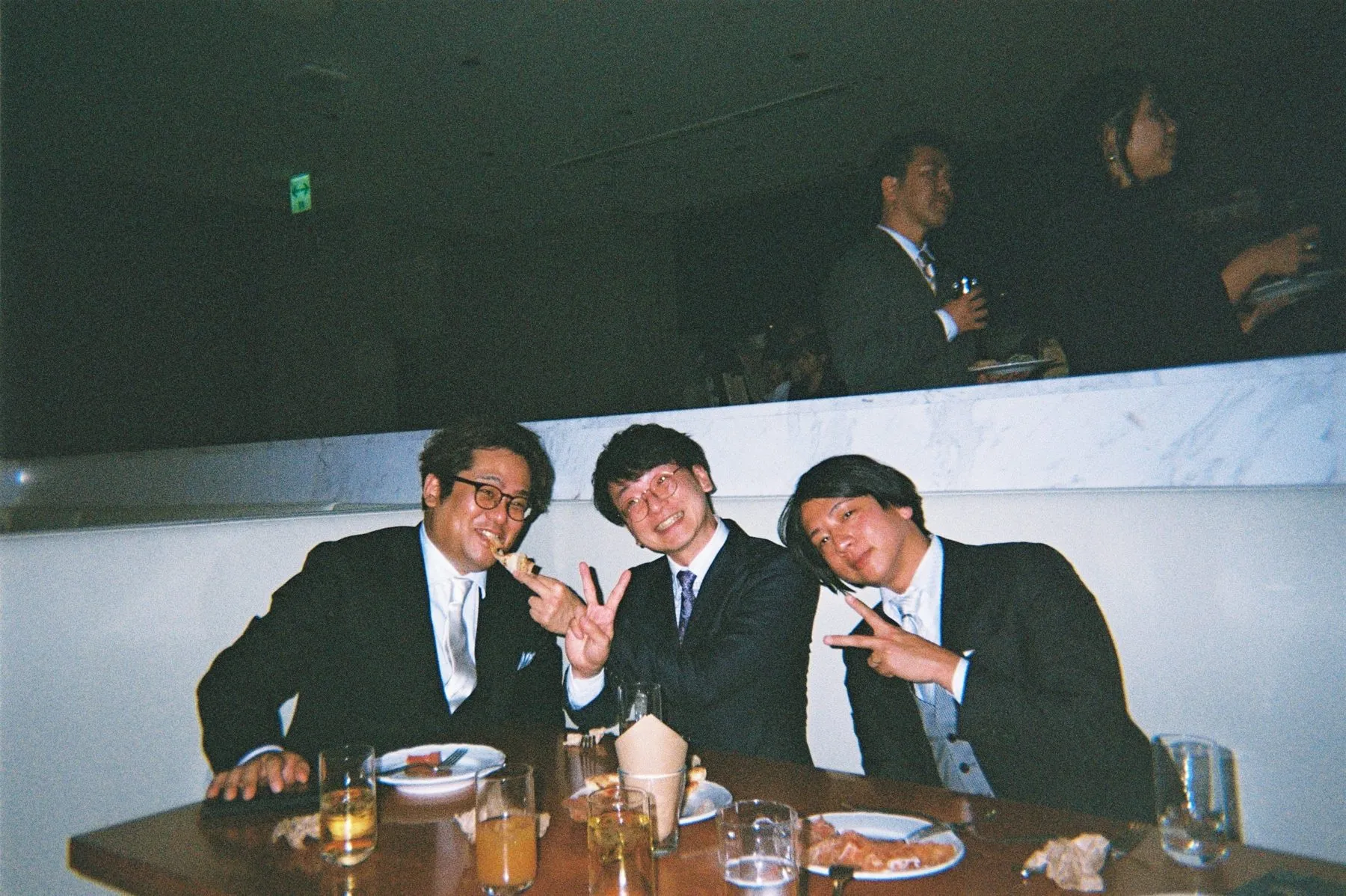 披露宴の卓でピースするゲスト3人