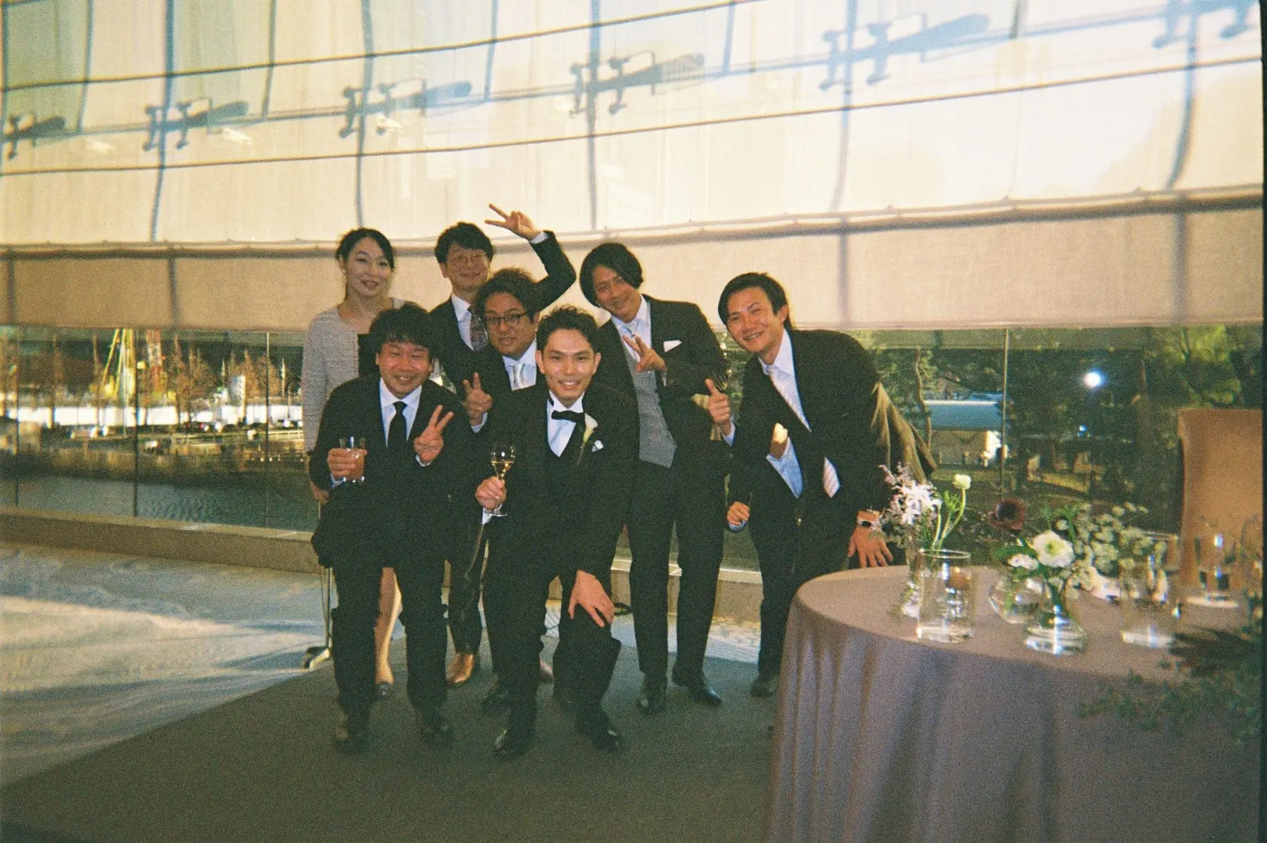 窓際で新郎とポーズをとるゲストたち