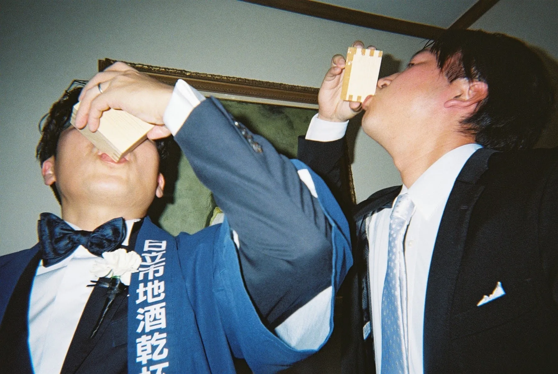 升で地酒を飲み干す、たすき姿の新郎とゲスト